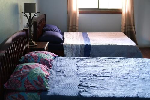 a bedroom with two beds and a window at Two houses with a private pool. in Pavones