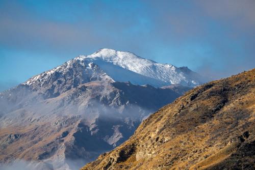 a mountain with snow on top of it at Aroha Apartment at the base of Coronet Peak in Queenstown