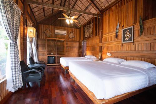 1 Schlafzimmer mit 2 Betten und einem Deckenventilator in der Unterkunft MEKONG SILT ECOLODGE in Cần Thơ