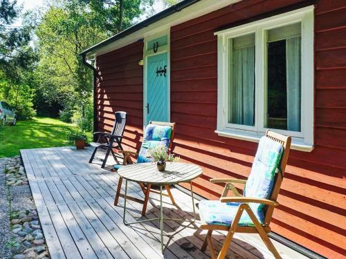 a patio with three chairs and a table on a house at 5 person holiday home in HEN N in Henån