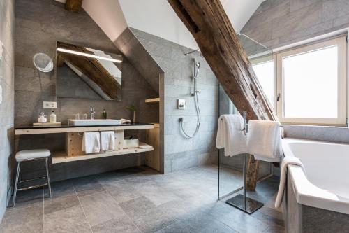 ein Badezimmer mit einem Waschbecken und einer Badewanne in der Unterkunft Meisser Hotel "superior" in Guarda