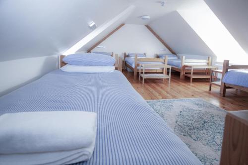 a attic bedroom with two beds and chairs at Bunk House - 4 Bedroom - Llangenith in Llangennith