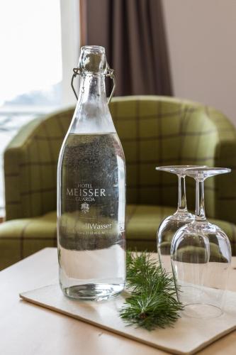 a bottle of water on a table next to two glasses at Meisser Hotel "superior" in Guarda