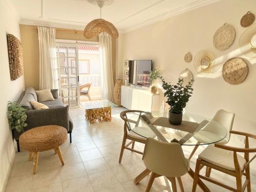 a living room with a glass table and chairs at Casa del Sol - with Home Office space in Playa de San Juan