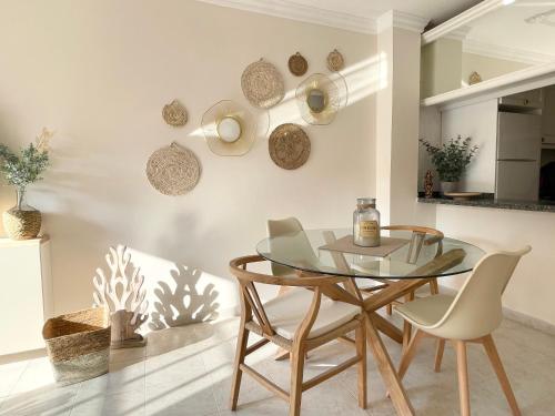 a dining room with a glass table and chairs at Casa del Sol - with Home Office space in Playa de San Juan