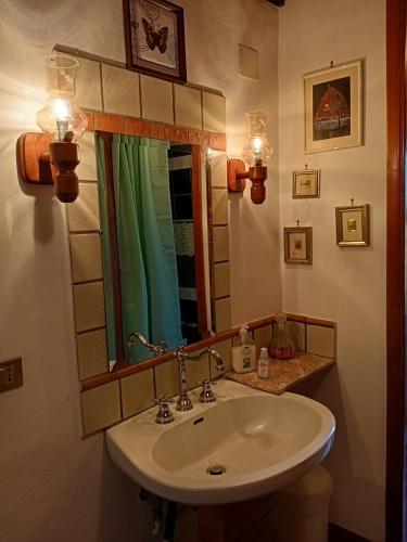 a bathroom with a sink and a mirror and lights at B&B Bellavista in Bagnoregio