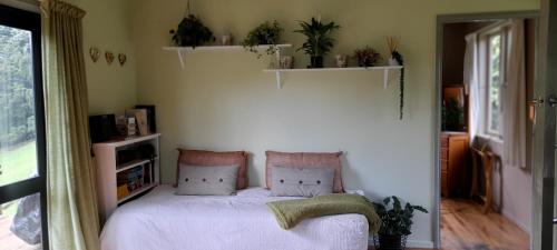 A bed or beds in a room at Earthsounds Country Cottage