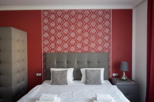 a bedroom with a large bed with a red wall at Villa Kiwi in Mikulov