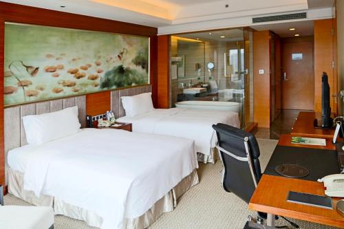 una camera d'albergo con 2 letti e una scrivania di Grand Skylight International Hotel Shenzhen Guanlan Avenue a Bao'an