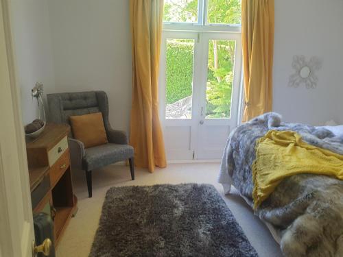 a bedroom with a bed and a chair and a window at Windhaven Bed & Breakfast in Duntroon