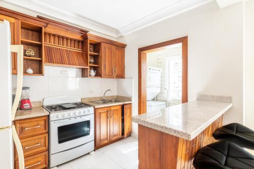 a kitchen with wooden cabinets and a white stove top oven at Caribbean Treasure in Punta Cana
