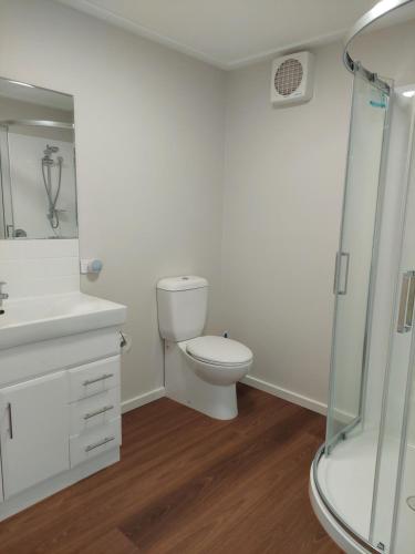 a white bathroom with a toilet and a shower at Spring Hill in Forth