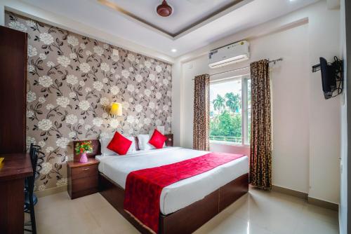 a bedroom with a large bed with red pillows at Almas Residency in Cochin