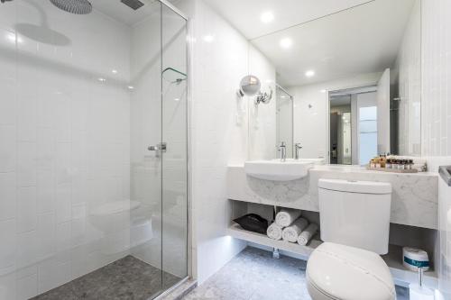 a bathroom with a toilet and a sink and a shower at Kingsford Smith Motel in Brisbane