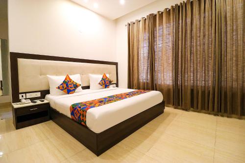 - une chambre avec un grand lit et une fenêtre dans l'établissement FabHotel Oyster Villa, à Gurgaon