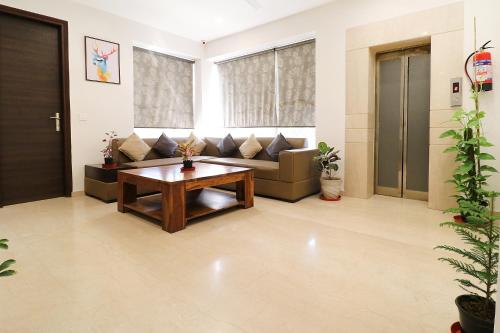 a living room with a couch and a table at FabHotel Oyster Villa in Gurgaon