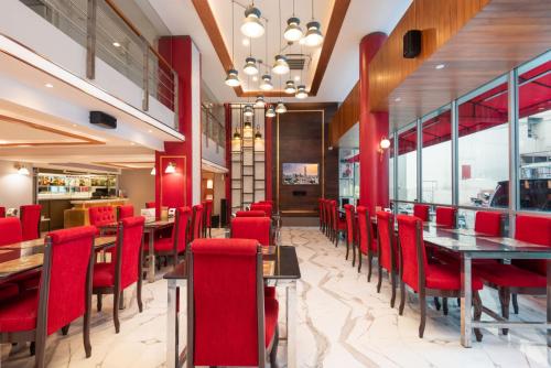 a dining room with red chairs and tables in a restaurant at Khurana Inn in Bangkok