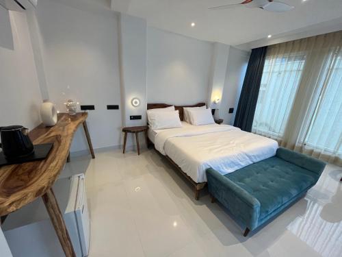 a bedroom with a bed and a blue couch at Moustache Udaipur Luxuria in Udaipur