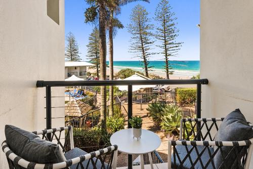 balcón con mesa y sillas y la playa en Coolum Beachside Studio, en Coolum Beach