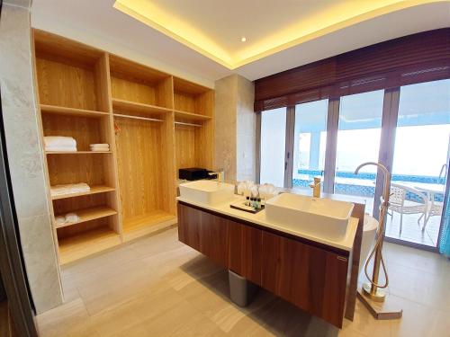 a bathroom with a large sink and a large window at Pacific Regency Beach Resort, Port Dickson in Port Dickson