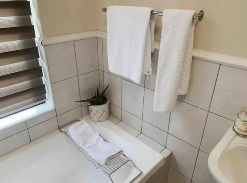 a white bathroom with a sink and towels at Lillys Quarter 1 - Newly Renovated! in Sandton