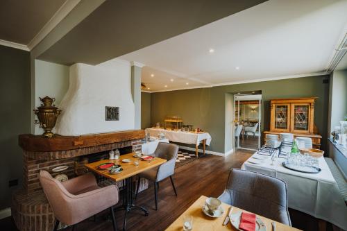 a dining room with a fireplace and tables and chairs at Antik-Hotel EICHENHOF in Bad Salzuflen