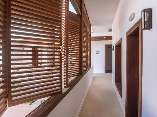 a hallway with wooden blinds on the window of a house at Casa da Djedja in Mindelo