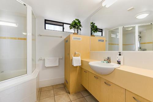 a bathroom with a sink and a mirror at Coolum Beachside Apartments in Coolum Beach