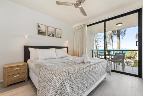 a bedroom with a bed and a balcony at Coolum Beachside Apartments in Coolum Beach