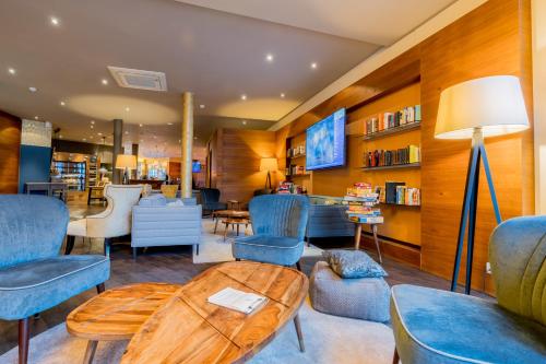 a living room with blue chairs and a table at Hotel Bacchus in Bensheim
