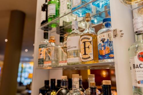 a shelf filled with lots of bottles of alcohol at Hotel Bacchus in Bensheim