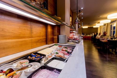a buffet line in a restaurant with food at Hotel Bacchus in Bensheim