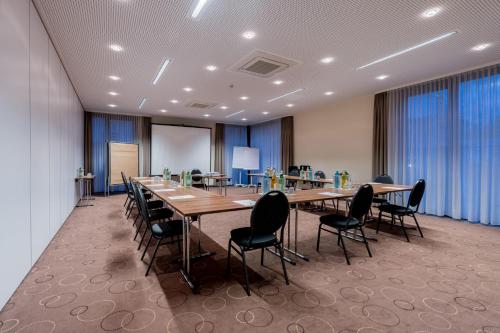 a conference room with long tables and chairs at Hotel Bacchus in Bensheim