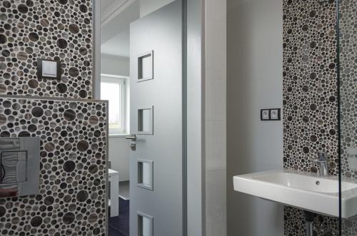 a bathroom with a sink and a glass shower door at Villa Kiwi in Mikulov