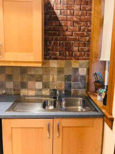 a kitchen with a sink and a brick wall at Station View Lodge - near Balbirnie House Markinch in Markinch