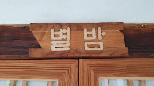 a sign on top of a wooden door at Greem Guesthouse in Jeonju