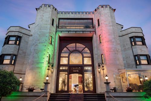 a building with a lit up front of it at Chatto Hotel in Tuzla
