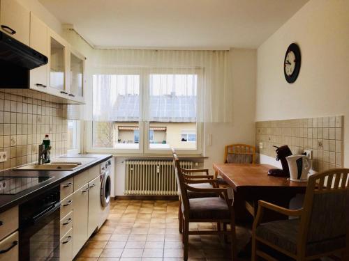 a kitchen with a table and chairs and a dining room at Apartamente Pfullingen in Pfullingen