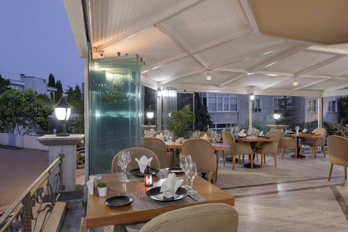 a restaurant with tables and chairs on a patio at Chatto Hotel in Tuzla