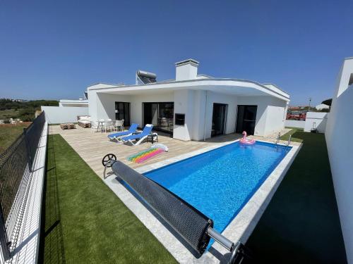a villa with a swimming pool in front of a house at Casa Felino in Nadadouro