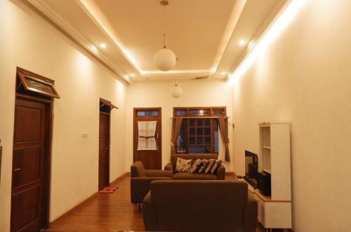 uma sala de estar com um sofá e uma televisão em AINUN VILLA DIENG em Banjarnegara