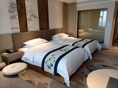 Postel nebo postele na pokoji v ubytování Baoying Jinling Hotel