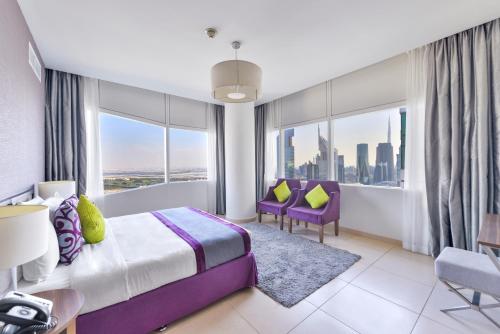 a hotel room with a bed and a large window at Nassima Tower Hotel Apartments in Dubai