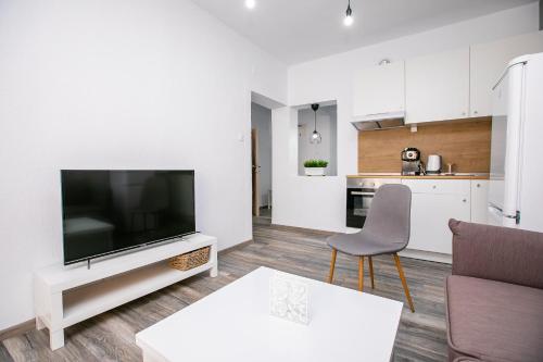 a living room with a flat screen tv and a kitchen at Aparthouse Heaven in Sandanski