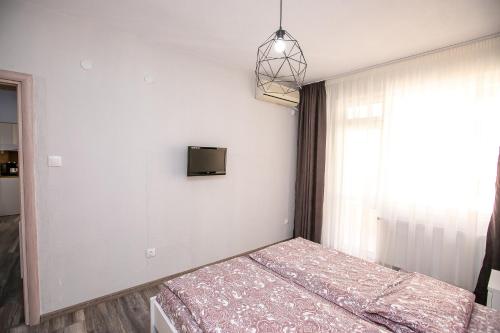 a bedroom with a bed and a tv on the wall at Aparthouse Heaven in Sandanski