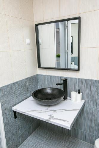 a bathroom with a sink and a mirror at Aparthouse Heaven in Sandanski