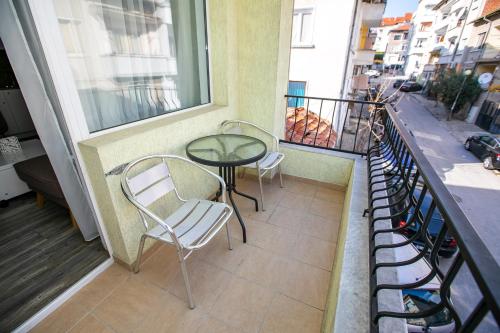 a balcony with two chairs and a table and a window at Aparthouse Heaven in Sandanski