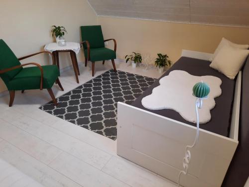 a bedroom with a bed and two chairs and a table at Sarkcsillag Vendégház in Kiskőrös