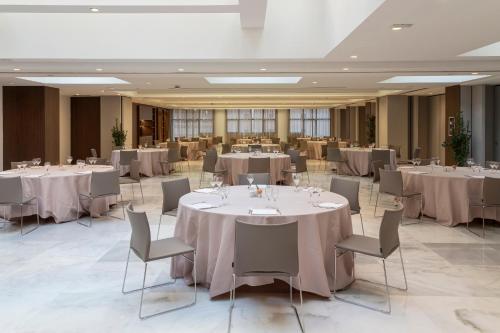 a banquet hall with white tables and chairs at Meliá Milano in Milan