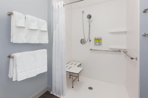 a white bathroom with white towels and a shower at Holiday Inn Express & Suites - Cedar Springs - Grand Rapids N, an IHG Hotel in Cedar Springs